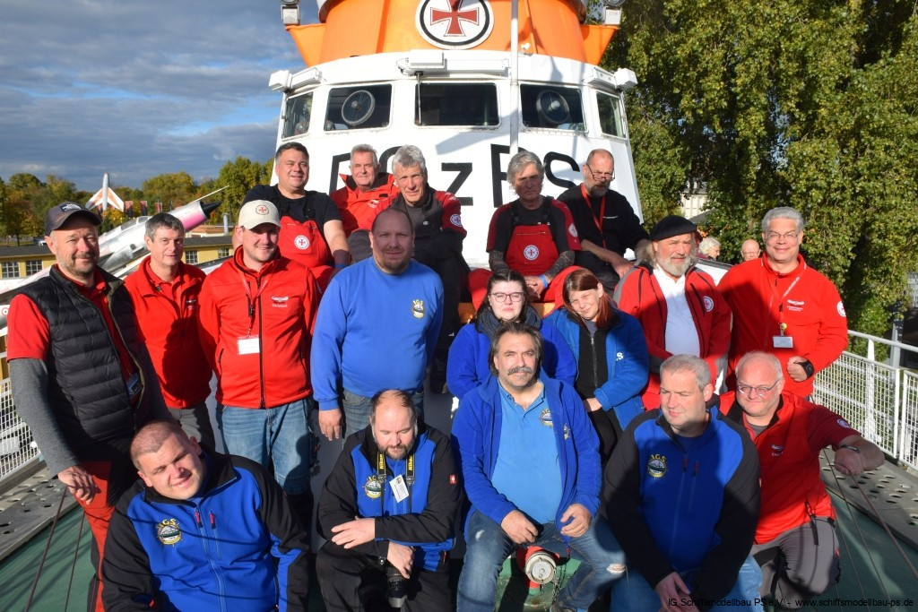 Gruppenfoto von Mitgliedern des IG Schiffsmodellbau PS e.V. vor einem Modellschiff, alle in Vereinskleidung.